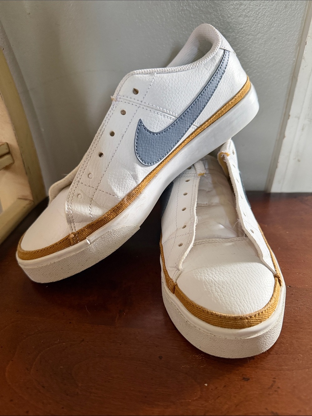 Nike White Leather Low-Top Sneakers with Blue Swoosh and Gold Accent